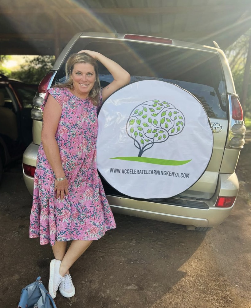 Alix Daykin beside her car with the Accelerate Learning Kenya spare-wheel cover