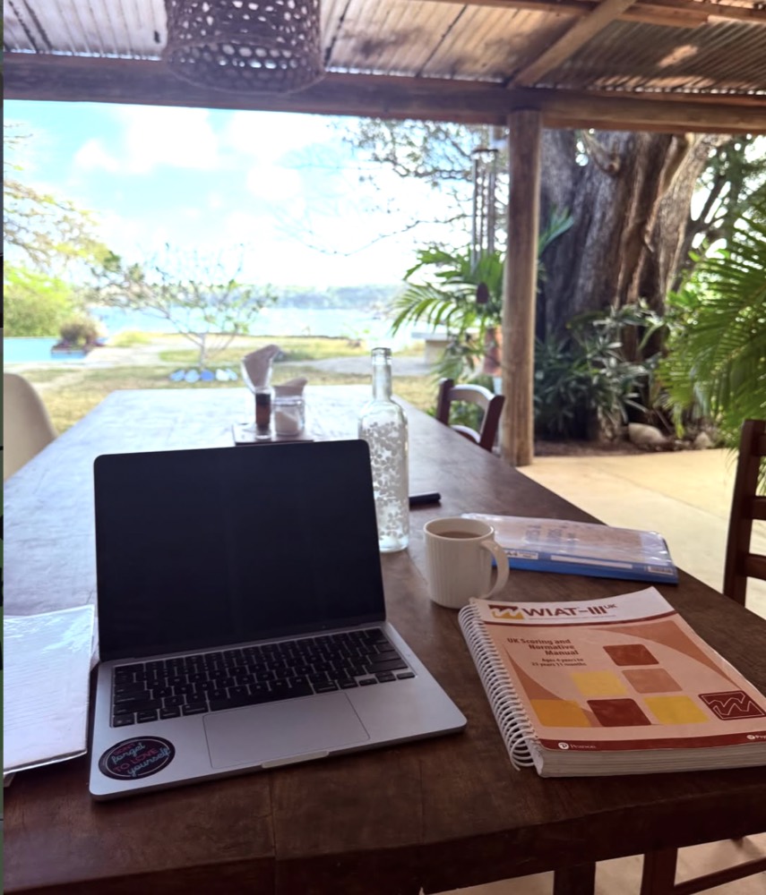 An assessment session set up with a laptop and the WIAT-III scoring manual